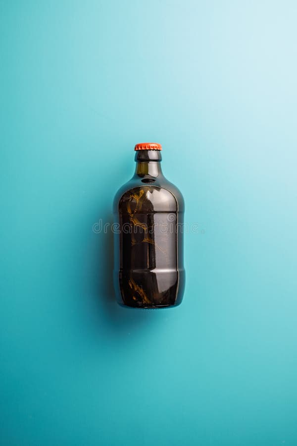 One beer bottle on blue background. Top view stock photos