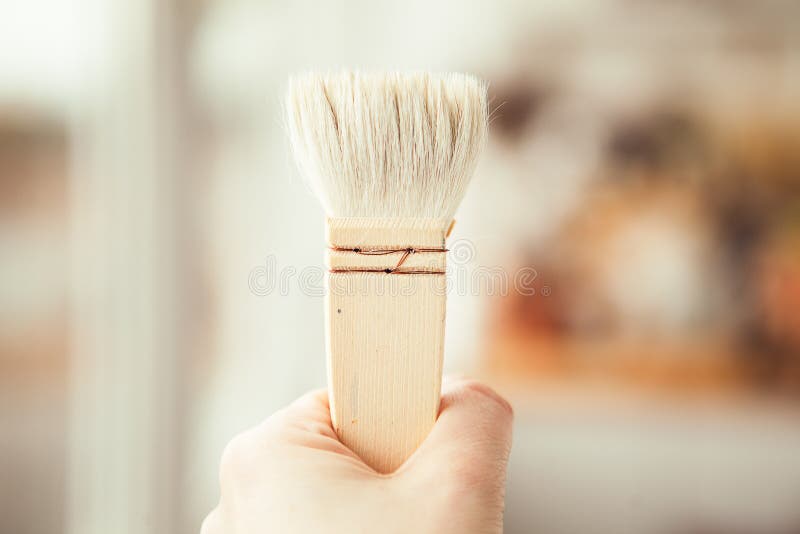 One Big White Paint Brush in Somebody`s Hand Stock Photo - Image of