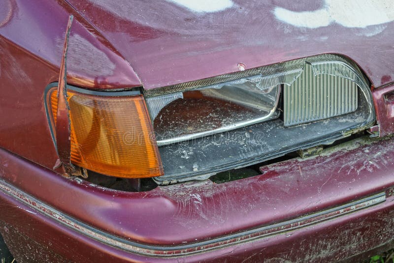 One Broken Glass Headlight on an Old Red Passenger Car Stock Photo