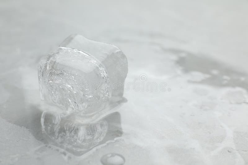 Square melting ice cubes on wet table Stock Photo by FabrikaPhoto