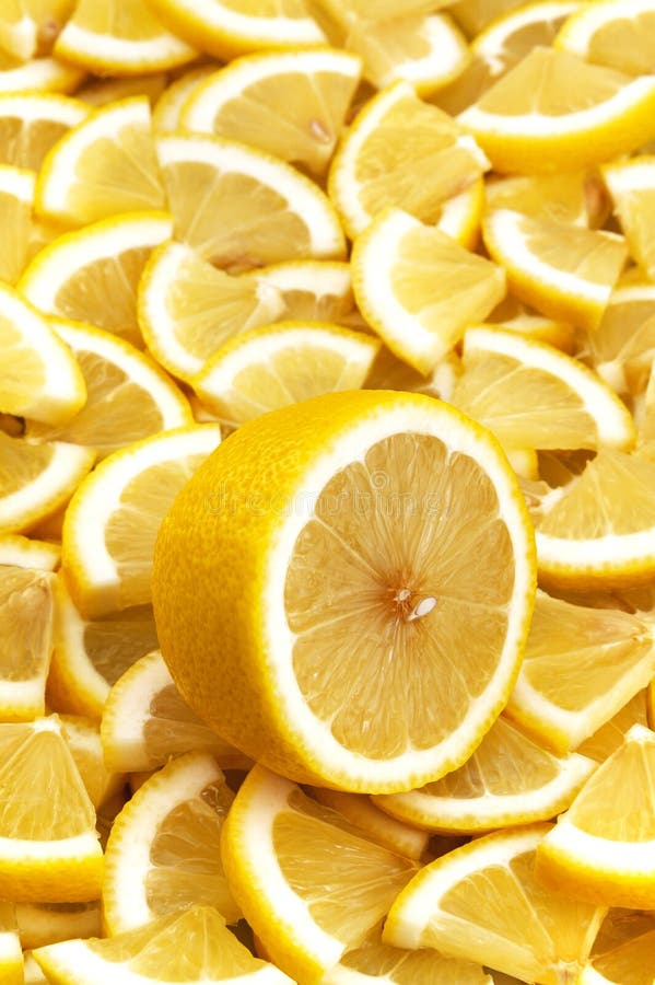 One cut lemon lies on a background of lemon slices. stock photos