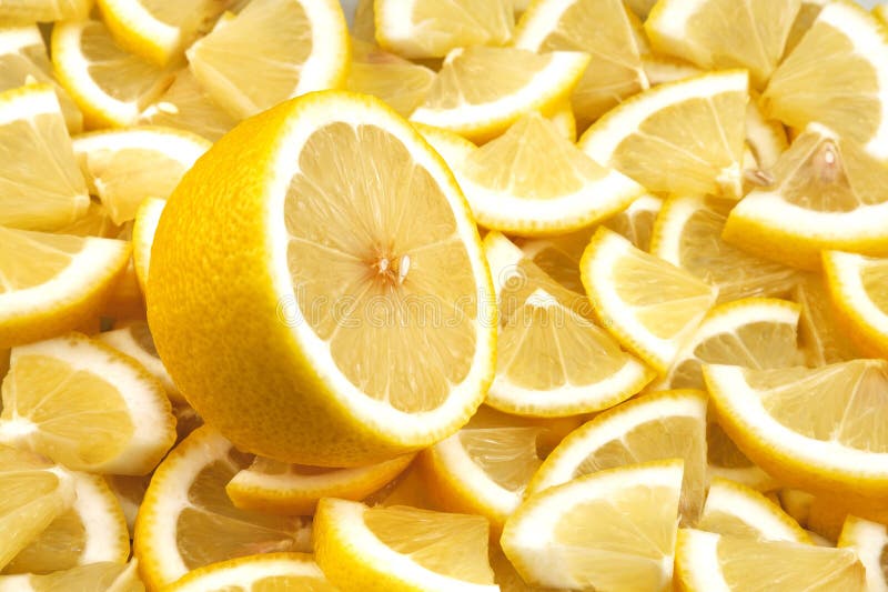 One cut lemon lies on a background of lemon slices. stock photo
