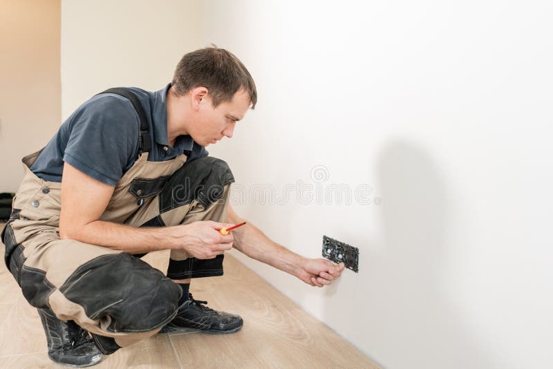 One Electrician Worker at Wiring Cable and Light Switch or Power Wall