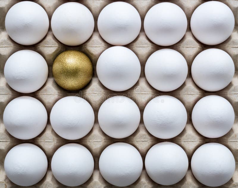 One golden egg among white eggs in a carton egg box