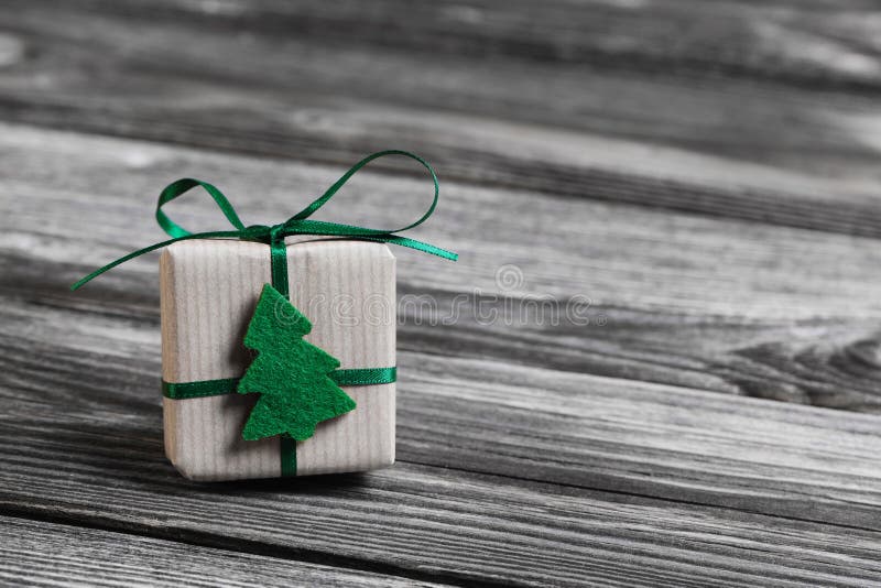 One green christmas present on wooden grey background.