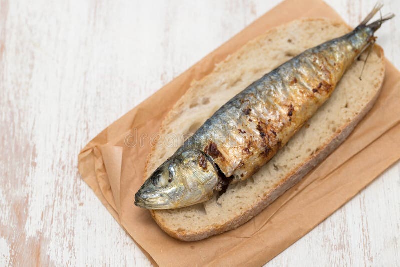 Grilled sardine on bread on white background