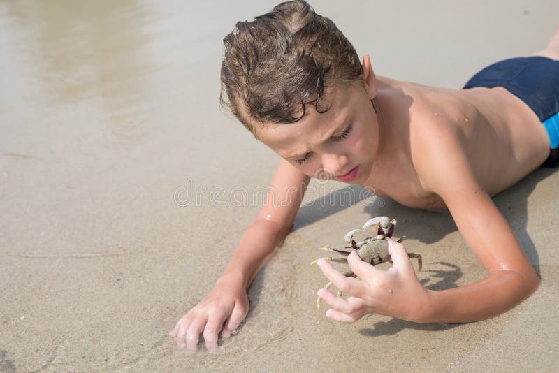 One happy little boy playing on the beach at the day time