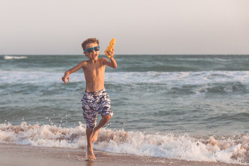 One happy little boy playing on the beach at the day time.