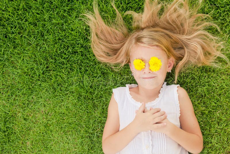One happy little girl lying on the grass stock image One happy little girl lying on the grass stock image