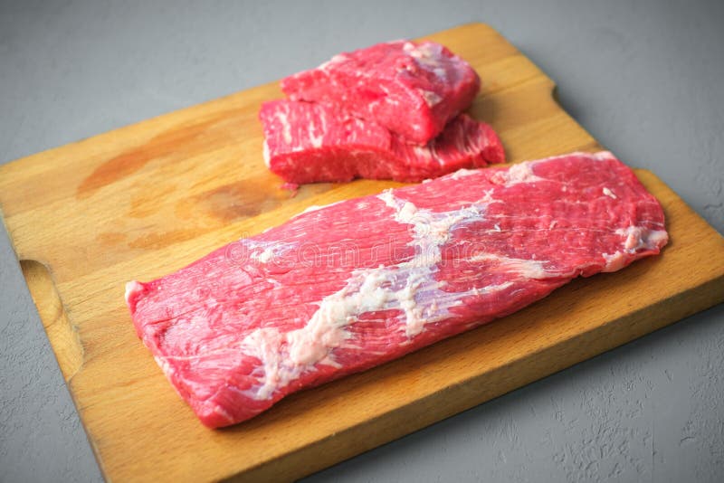 Portioned slices of raw meat on a cutting board. Fresh pieces of chopped  beef tenderloin close-up. Five juicy slices of beef. Ingredients for  preparin Stock Photo - Alamy