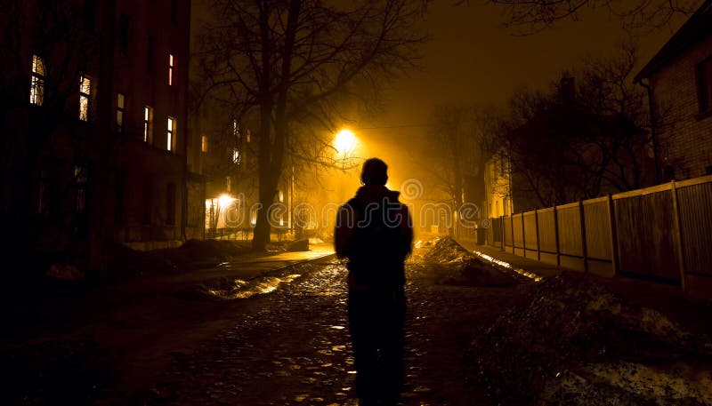 One man on the foggy street at night