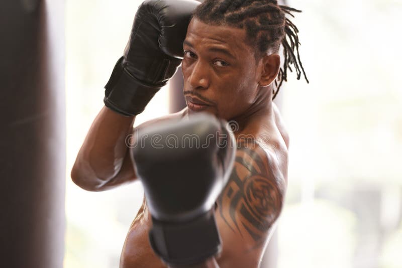 One Mean Upper Cut. Portrait of a Young Boxer Practicing in a Gym. Stock Photo Image of