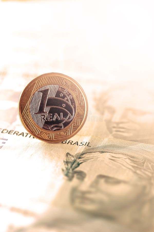 One real coin and gold bars. Concept of appreciation of the Brazilian currency in the stock market stock photography