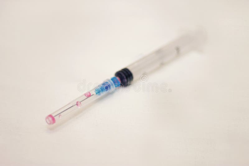 One Syringe with Cap and Needle after Using on the White Bckground