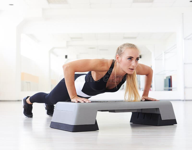 One woman doing abdominal push ups posture in gym stock photo One woman doing abdominal push ups posture in gym stock photo