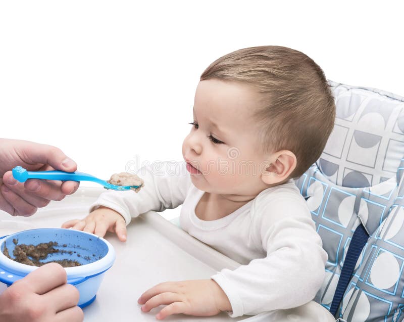 The one-year-old kid eats porridge