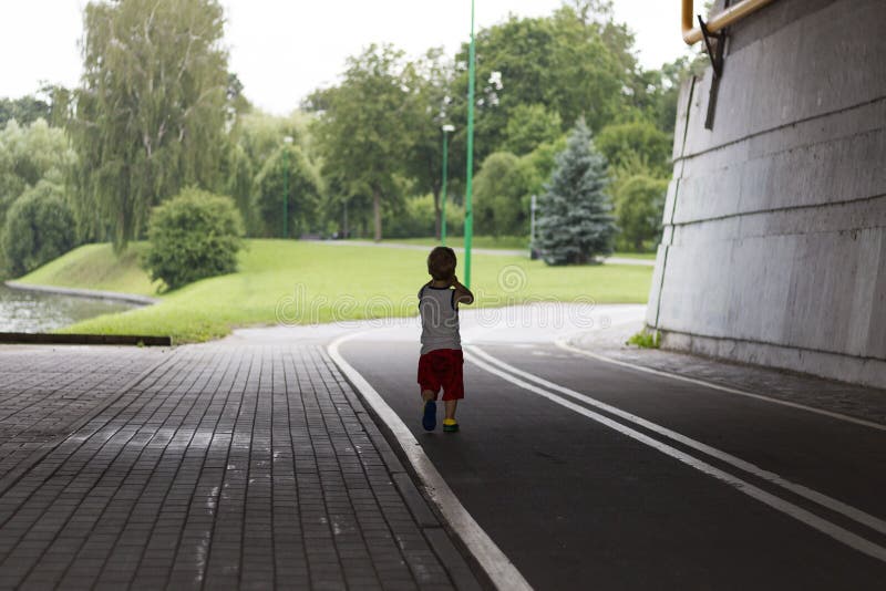 One year toddler running in the summer park. Back view. royalty free stock images