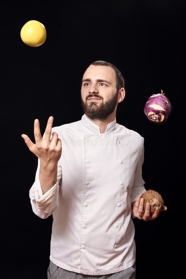 One young man, chief uniform, throwing food, studio photoshoot, having fun. stock image One young man, chief uniform, throwing food, studio photoshoot, having fun. stock image