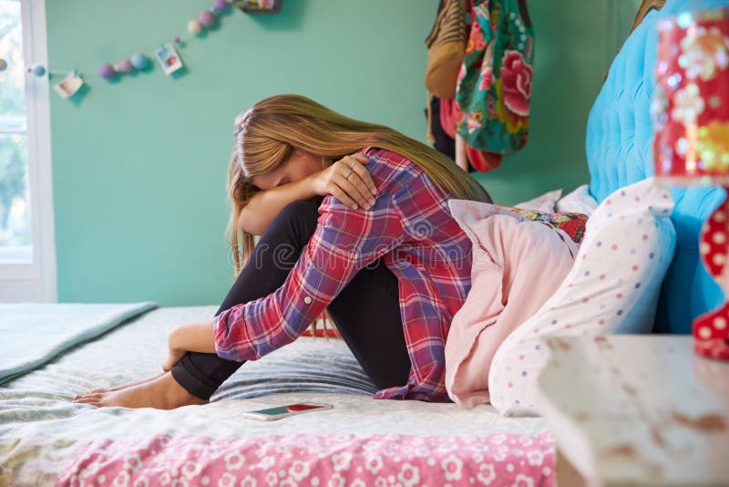 Ongelukkige Vrouwenzitting op Bed thuis stock afbeeldingen Ongelukkige Vrouwenzitting op Bed thuis stock afbeeldingen