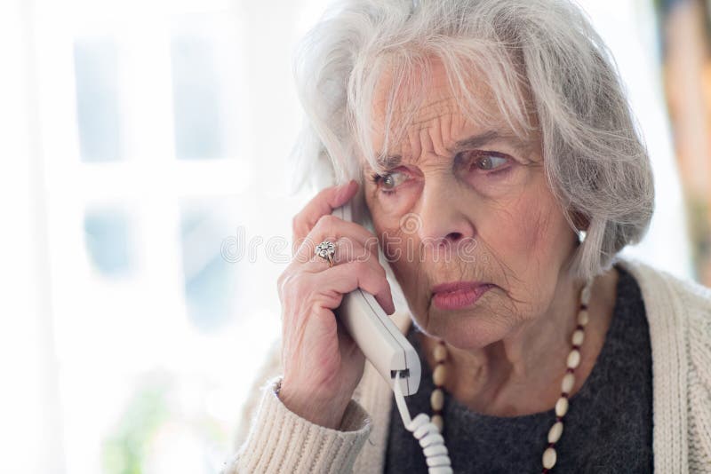 Ongerust gemaakte Hogere Vrouw die Telefoon thuis beantwoorden