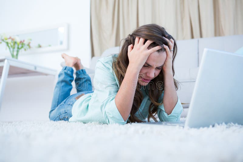 Ongerust gemaakte vrouw die haar laptop met behulp van stock afbeelding Ongerust gemaakte vrouw die haar laptop met behulp van stock afbeelding