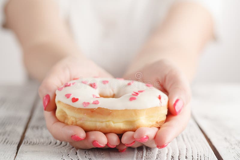 Ongezonde kost en het eten van concept - sluit omhoog van vrouwelijke handholding verglaasde doughnut royalty-vrije stock foto's Ongezonde kost en het eten van concept - sluit omhoog van vrouwelijke handholding verglaasde doughnut royalty-vrije stock foto's