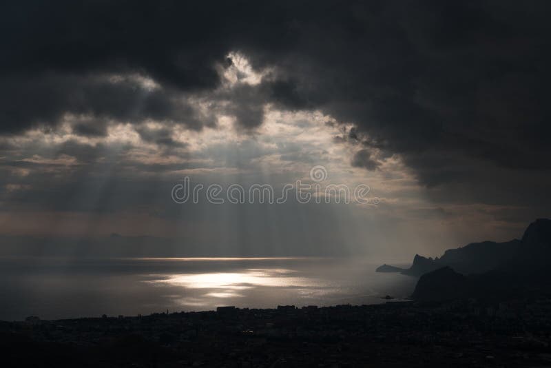Onheilspellende wolken en de barstende stralen van licht over het golfoverzees stock foto Onheilspellende wolken en de barstende stralen van licht over het golfoverzees stock foto