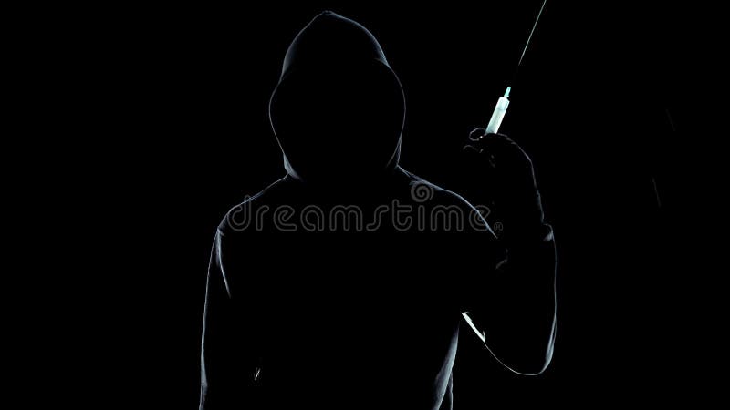 Onherkenbare mannelijke holdingsspuit met een kap op zwarte achtergrond, drugconcept royalty-vrije stock foto Onherkenbare mannelijke holdingsspuit met een kap op zwarte achtergrond, drugconcept royalty-vrije stock foto