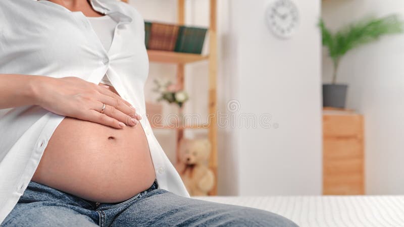 Onherkenbare zwangere vrouw die een buik stroopt geniet van het moederschap met zorg liefdesgevoeligheid sluiting