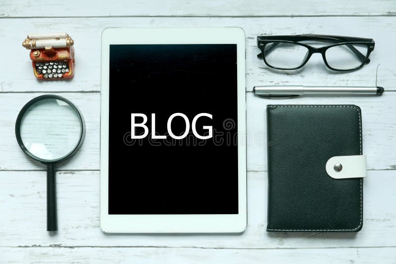 Online digital social media blog concept. Top view of magnifying glass,glasses,pen,notebook and tablet written with Blog on white stock photography Online digital social media blog concept. Top view of magnifying glass,glasses,pen,notebook and tablet written with Blog on white stock photography