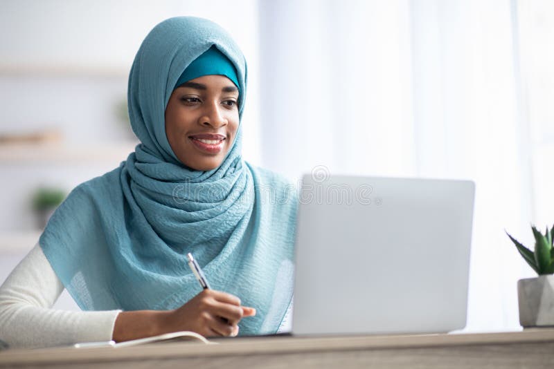 Online Education. Black Muslim Lady In Hijab Studying With Laptop At Home