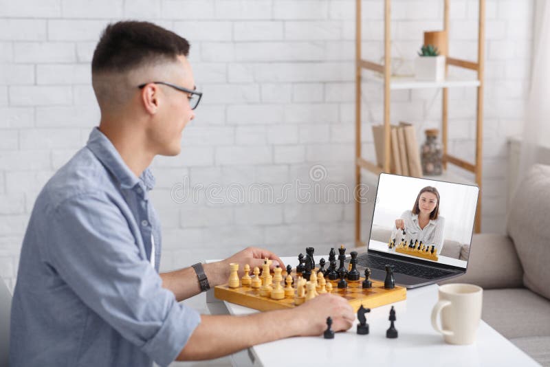 Teenage boy learning to play chess online with tablet computer