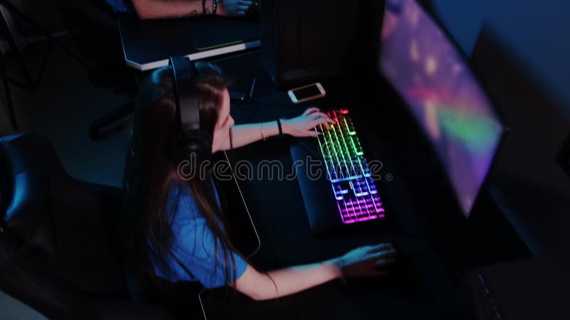 Online gaming - a company of three friends playing games in neon club