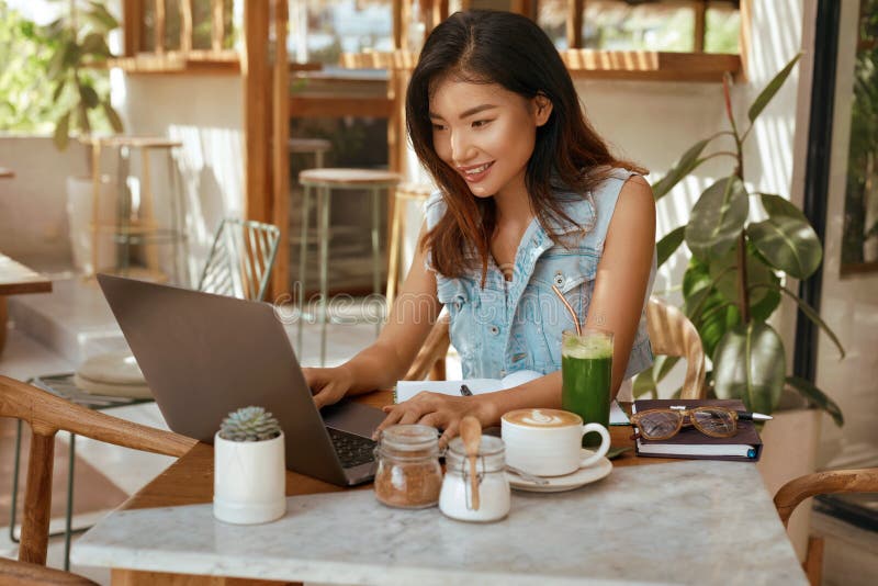 Online Job. Girl With Laptop At Cafe. Business Woman In Jeans Outfit Working At Coffee Shop. Digital Nomad Lifestyle royalty free stock image