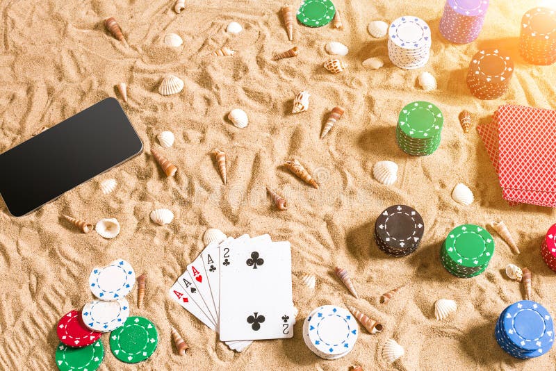 Online poker game on the beach with digital smart and stacks of chips. Top view