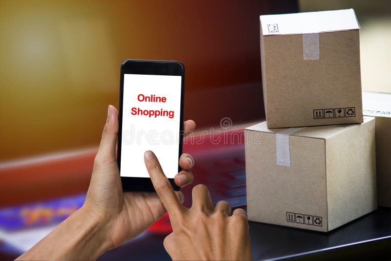 Online shopping concept e-commerce delivery buying service. square cartons shopping on laptop keyboard, showing customer order via the internet on smartphone.