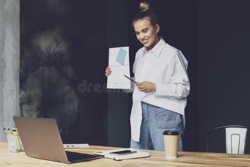 Business woman holds online meeting. Beautiful girl in white shirt holds documents in her hand and communicates through web camera. Remote work of employee of large financial company. Business woman holds online meeting. Beautiful girl in white shirt holds documents in her hand and communicates through web camera. Remote work of employee of large financial company