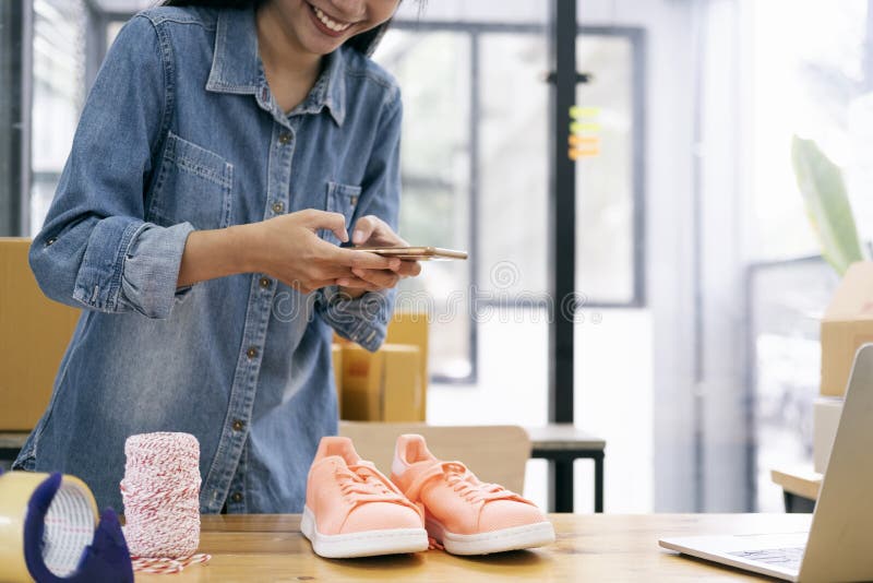 Online-Verkäufer fotografieren ein Produkt zum Upload auf den Online-Shop lizenzfreies stockbild Online-Verkäufer fotografieren ein Produkt zum Upload auf den Online-Shop lizenzfreies stockbild