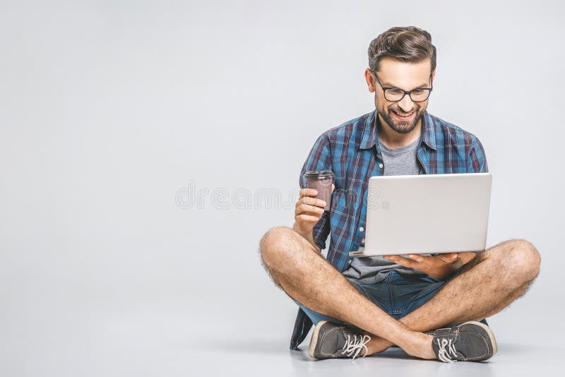 Online working concept. Casual business man relaxed working and browsing internet on laptop computer with coffee. Freelance