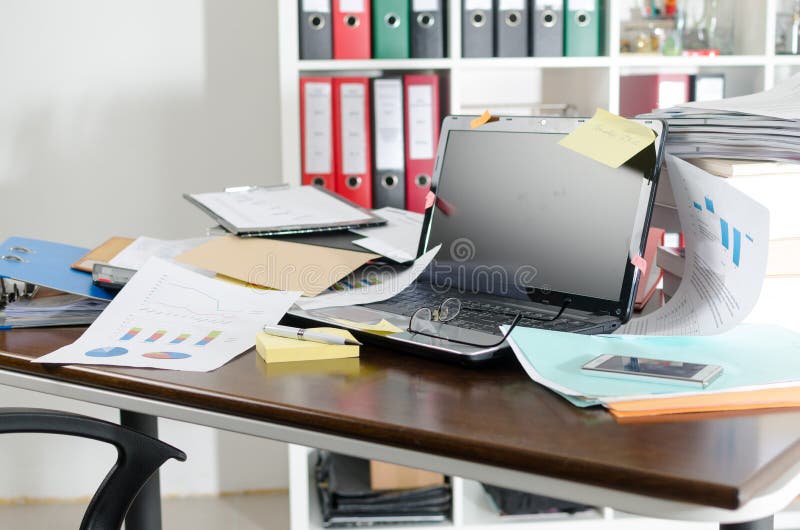 Onordelijk en volgestopt bureau stock afbeelding Onordelijk en volgestopt bureau stock afbeelding