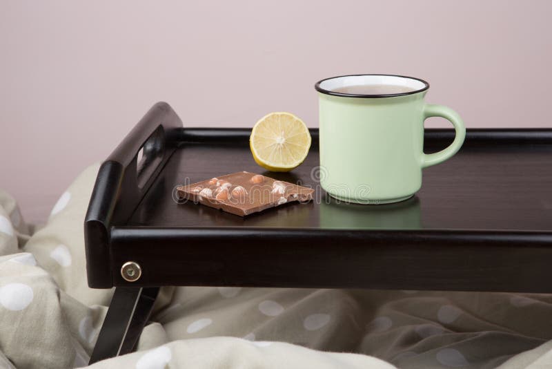 Ontbijt in bed - kop thee, citroen en chocolade op houten dienblad royalty-vrije stock afbeelding Ontbijt in bed - kop thee, citroen en chocolade op houten dienblad royalty-vrije stock afbeelding