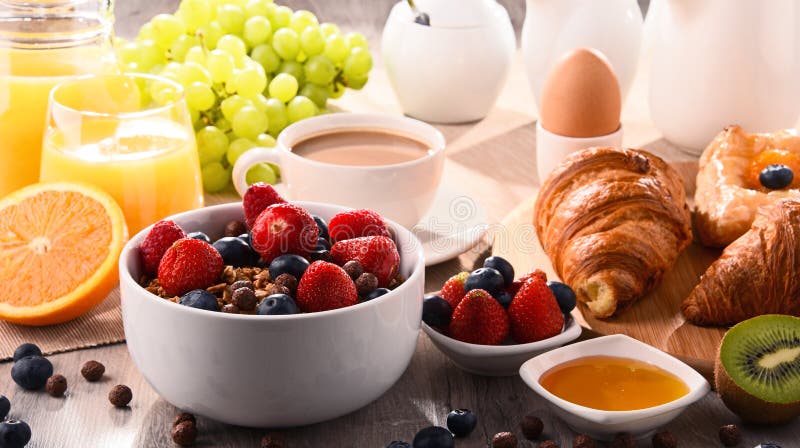 Ontbijt met koffie, sap, croissants en vruchten wordt gediend die