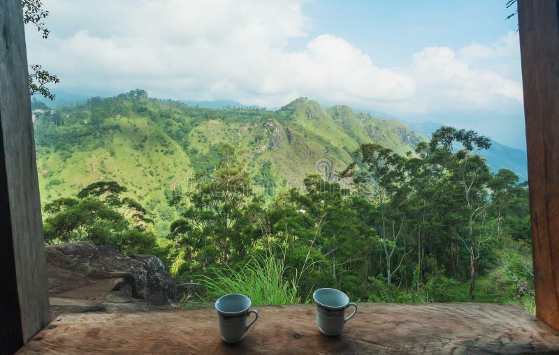 Ontbijt van een paar met koffiekoppen op groene heuvel onder blauwe hemel Romantisch landschap met bergen stock afbeeldingen Ontbijt van een paar met koffiekoppen op groene heuvel onder blauwe hemel Romantisch landschap met bergen stock afbeeldingen