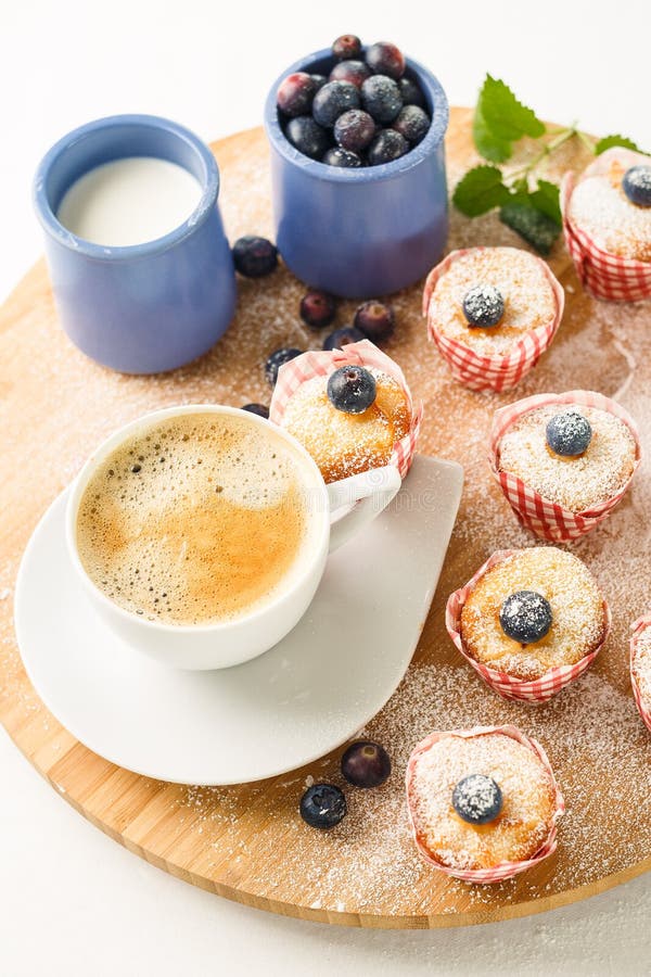 Ontbijtkoffie met minimuffins en bosbessen op een houten tribune royalty-vrije stock foto's Ontbijtkoffie met minimuffins en bosbessen op een houten tribune royalty-vrije stock foto's