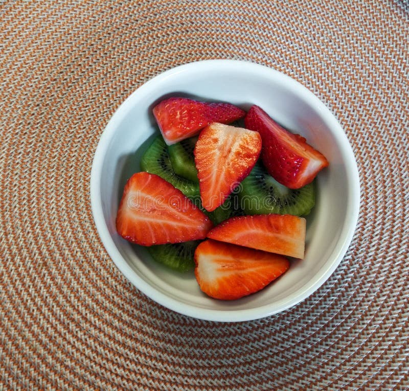 Ontbijtkom met aardbeien en kiwi op cirkeldoekachtergrond stock foto Ontbijtkom met aardbeien en kiwi op cirkeldoekachtergrond stock foto