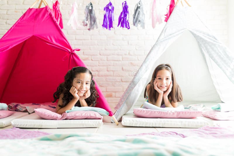 Ontspannen Meisjes met Handen op Chin Smiling In Teepee Tents royalty-vrije stock afbeelding Ontspannen Meisjes met Handen op Chin Smiling In Teepee Tents royalty-vrije stock afbeelding