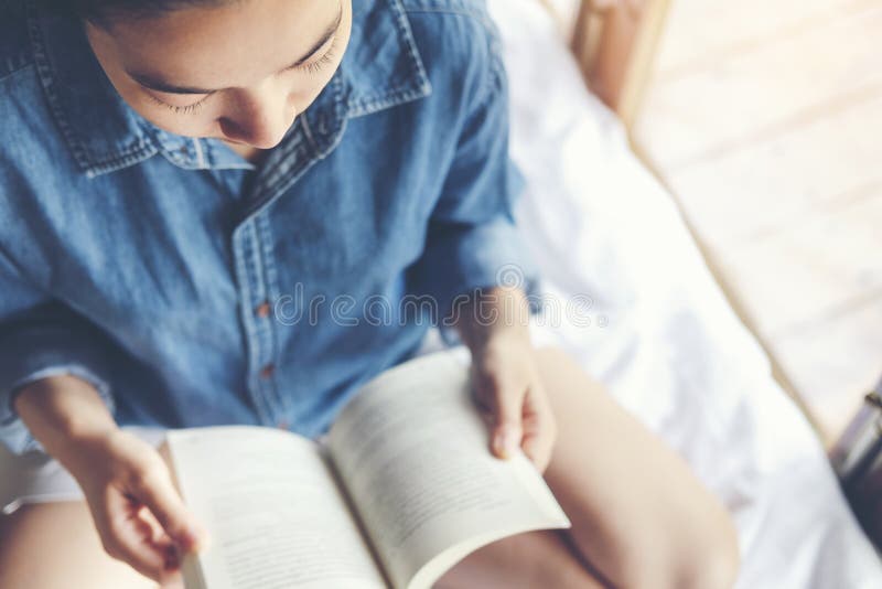 Ontspannen vrouw die een boek op bed in de ochtend lezen, vakantietijd stock afbeeldingen Ontspannen vrouw die een boek op bed in de ochtend lezen, vakantietijd stock afbeeldingen