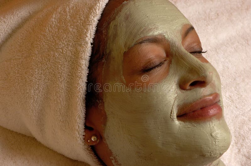Young woman relaxing at day spa with organic facial mask application. Young woman relaxing at day spa with organic facial mask application