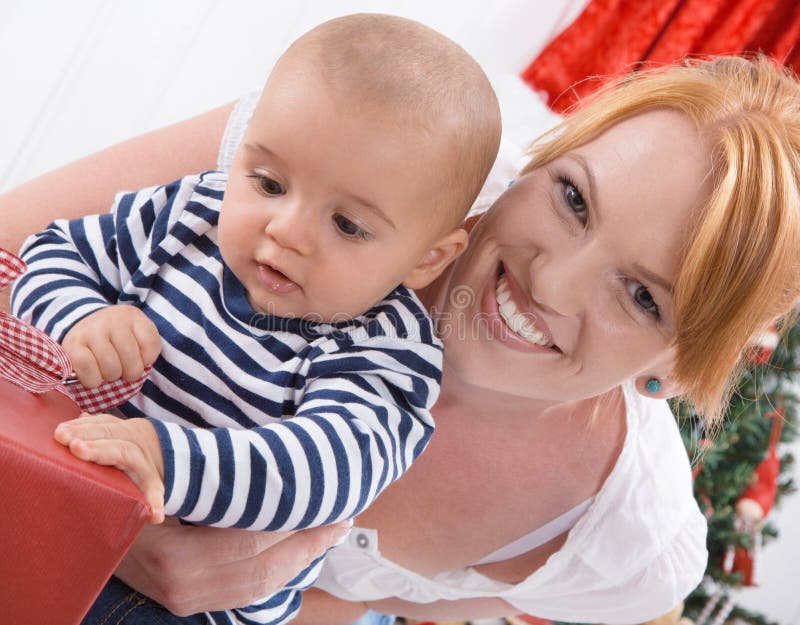 Onvoorwaardelijke liefde - moeder en baby die Kerstmis openen of birt stock foto Onvoorwaardelijke liefde - moeder en baby die Kerstmis openen of birt stock foto