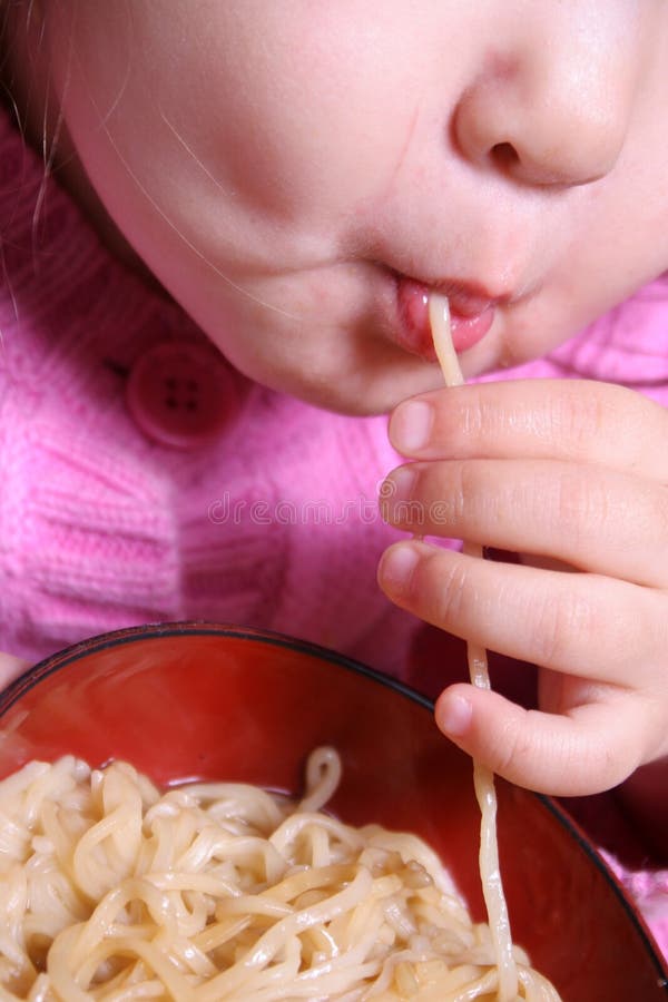 Child slurping up a bowl of noodles. Child slurping up a bowl of noodles